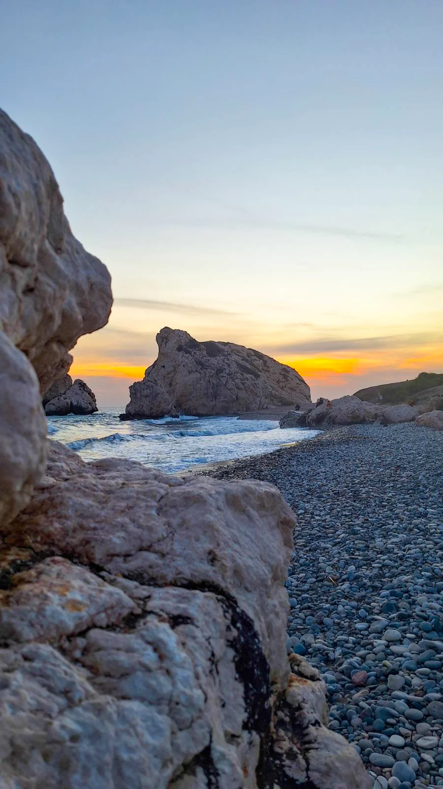 The legendary Aphrodite's Rock (Petra tou Romiou) at sunset on a pebble beach in Cyprus.
