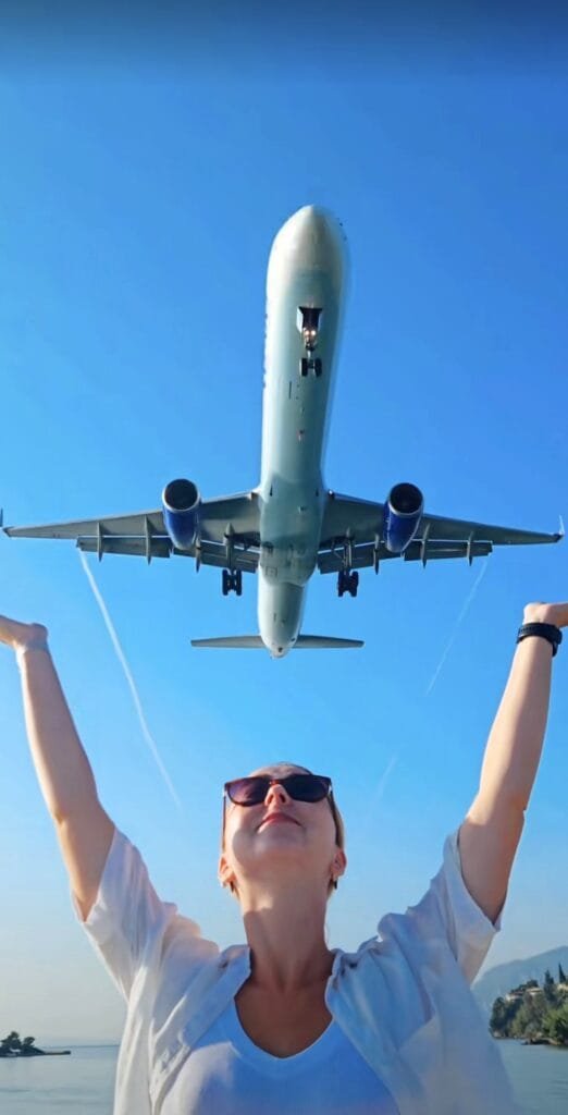 Joanna from Millennials Do Travel witnessing a low airplane landing at Kanoni viewpoint, Corfu.