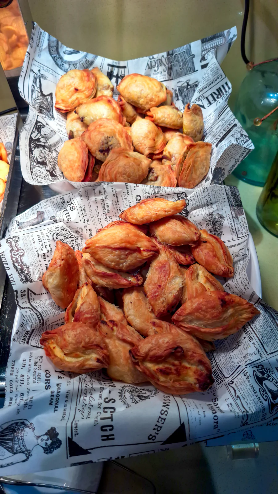 Świeżo upieczone maltańskie pastizzi podane na tradycyjnym papierze.