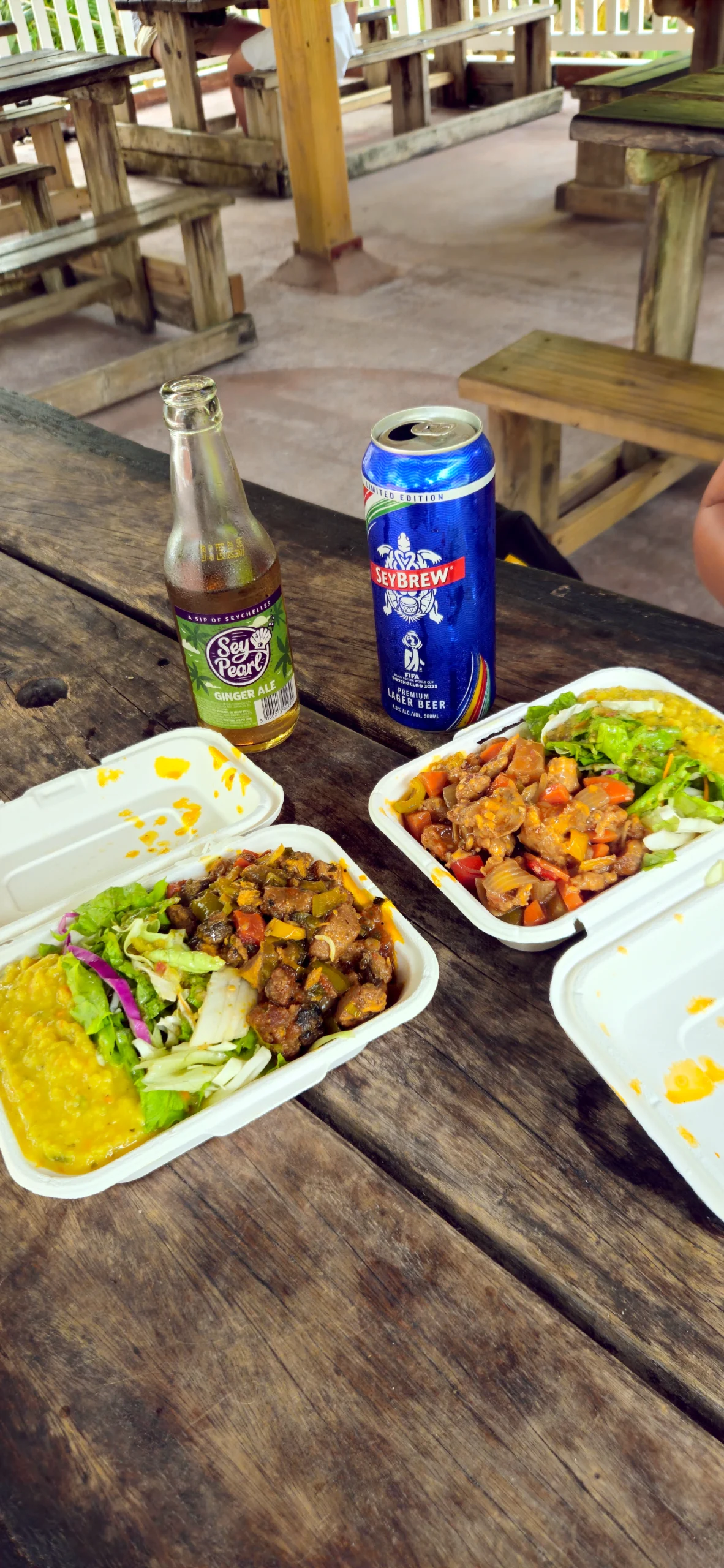 Traditional Seychelles Creole take-away food boxes with local SeyBrew beer and SeyPearl soda.