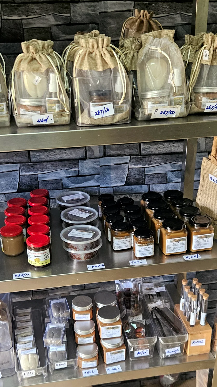 Półki wypełnione lokalnym, rzemieślniczym olejem kokosowym i dżemem w fabryce Virgin Coconut Oil na Praslin.