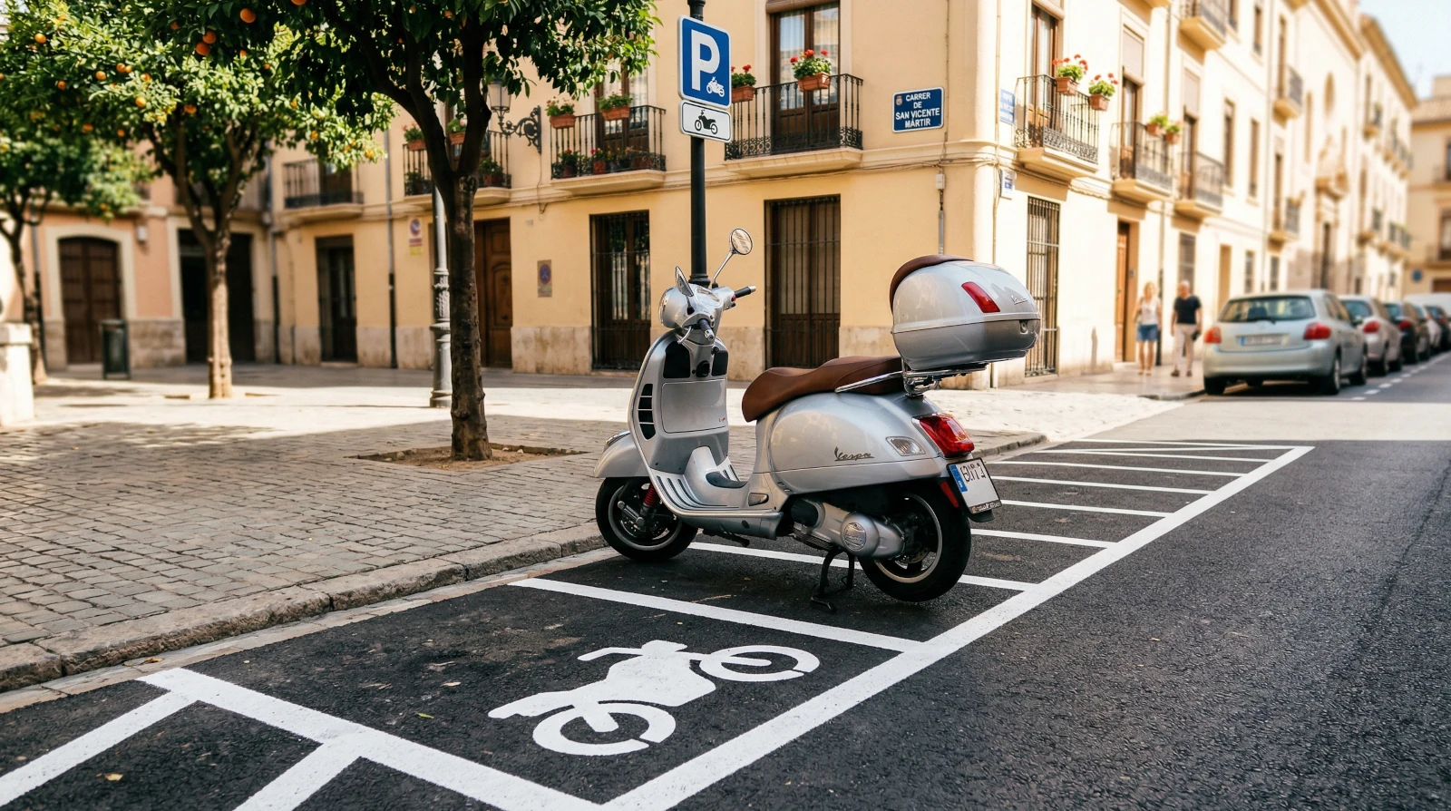 Skuter typu Vespa zaparkowany w wyznaczonej strefie dla motocykli oznaczonej na asfalcie w hiszpańskim mieście.