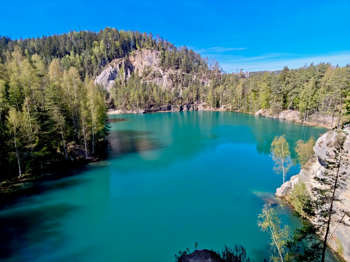 Turquoise water of Pískovna Lake at the entrance to Adršpach Rock City in the Czech Republic.