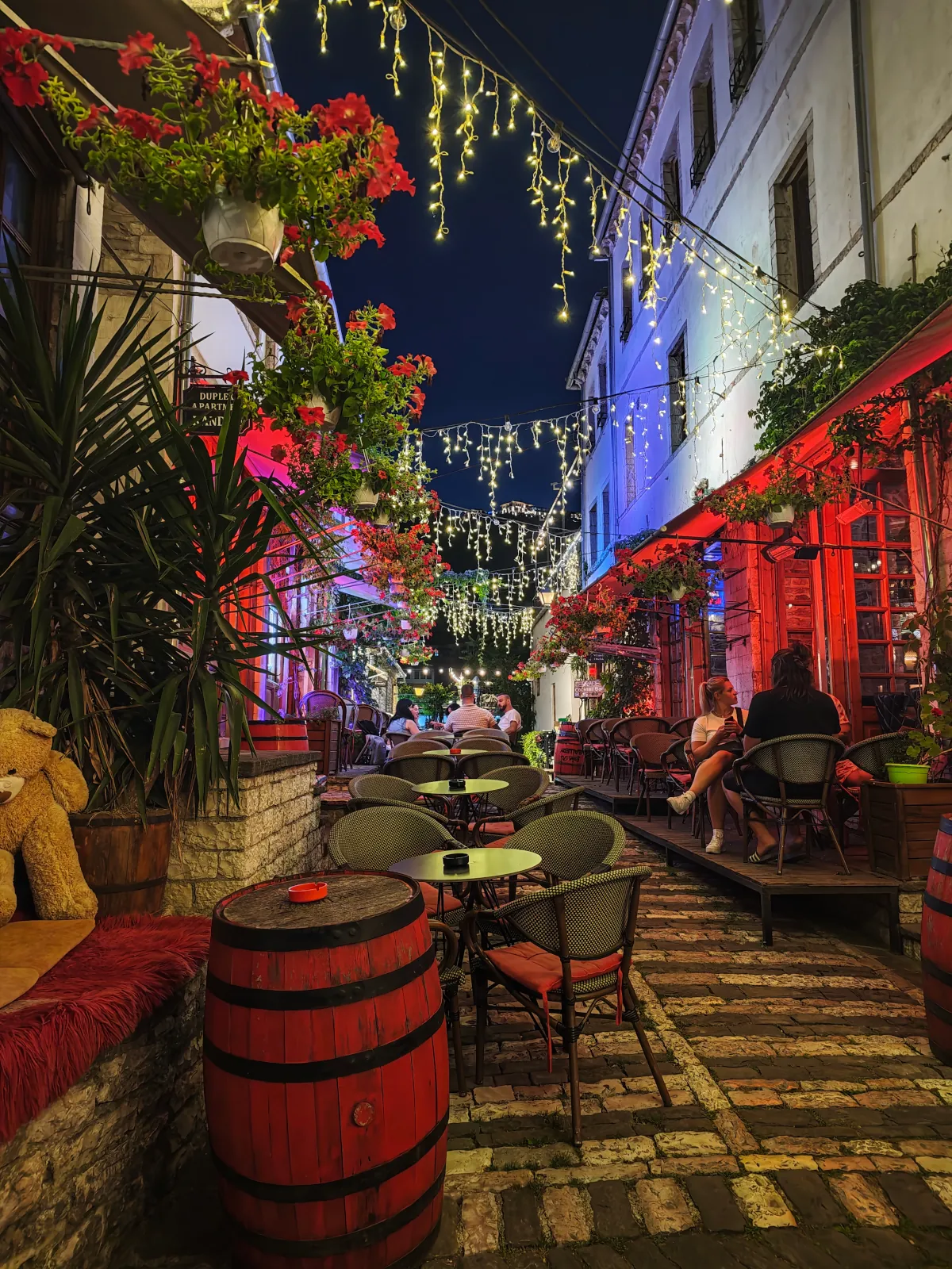 Traditional stone-paved street in the Old Bazaar of Gjirokastër, Albania, decorated with local handicrafts and shops.
