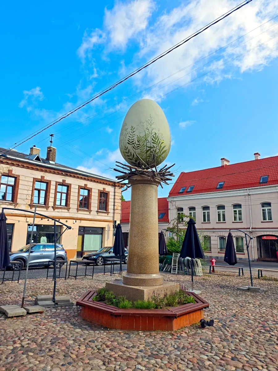 The giant painted Margutis Easter Egg sculpture standing on a stone column in a square near Halės Market in Vilnius.